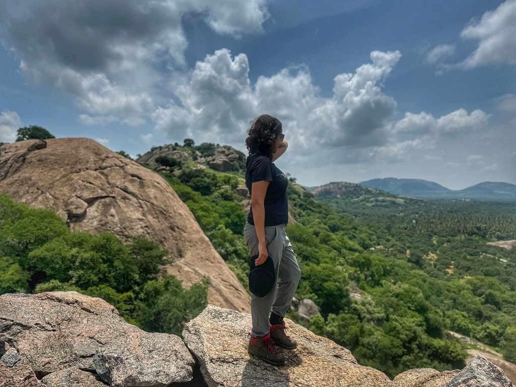 a girl standing seeing the nearby hills