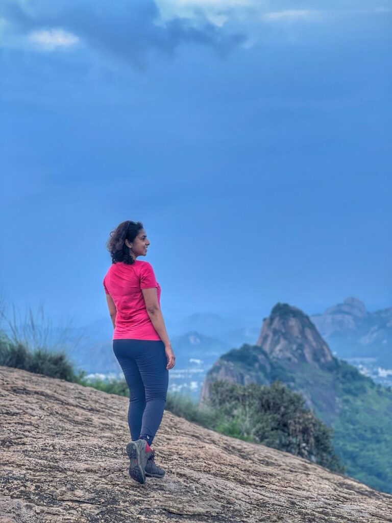 a girl standing at the peak of MuthurayaSwamy Betta